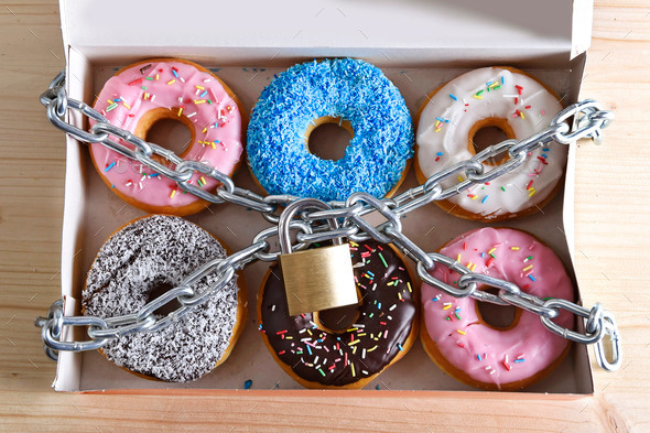 box full of tempting delicious donuts wrapped in metal chain and lock in sugar and sweet addiction