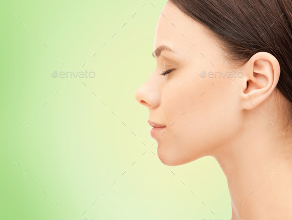 beautiful young woman face over green background
