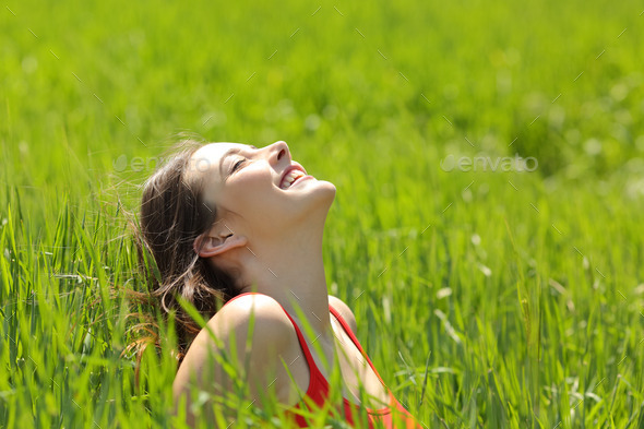 Happy girl face breathing fresh air in a meadow