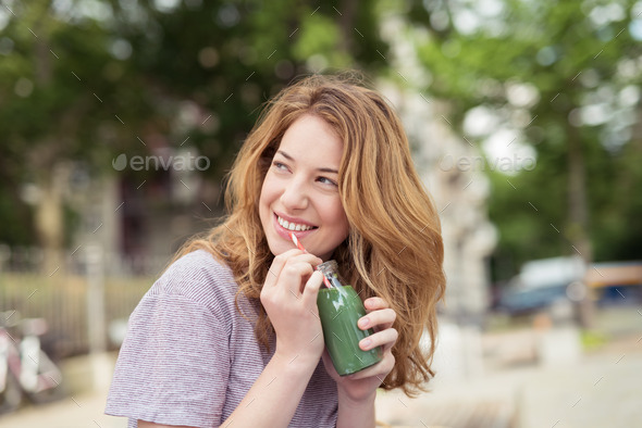 Cheerful Girl Holding Bottle of Juice, Looking Up