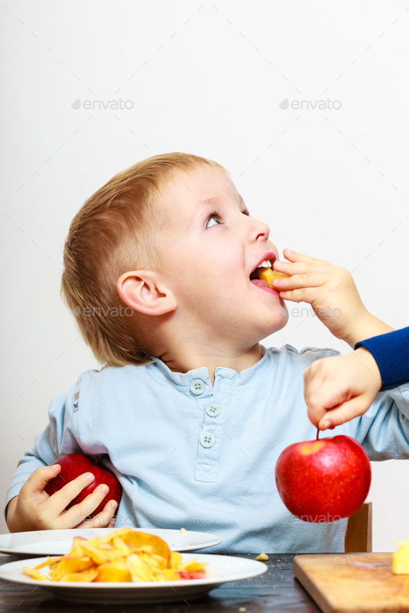 Little boys peeling apple cooking at home.