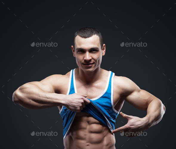 A man shows his abdominal muscles (Misc) Photo Download