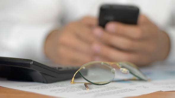 Businessman Using Smartphone at Office Table Businessman Using Smartphone at Office Table