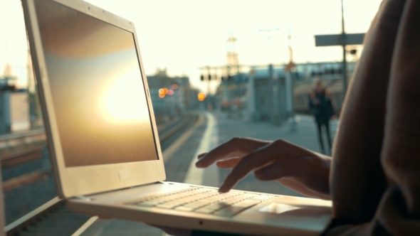 Woman Using Laptop At The Station Platform Woman Using Laptop At The Station Platform