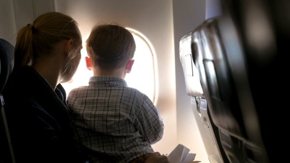 Mother And Son Looking Out Illuminator In Plane Mother And Son Looking Out Illuminator In Plane