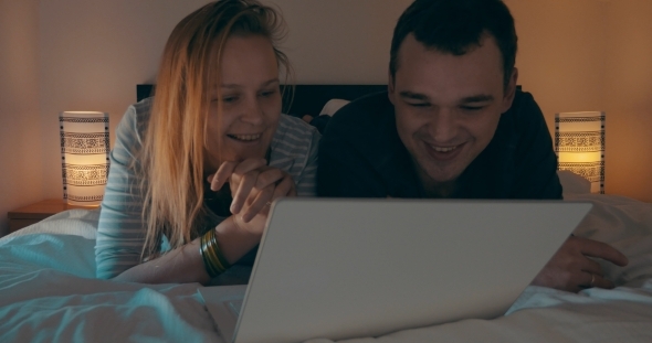 Couple In Bed Watching Movie On Laptop Couple In Bed Watching Movie On Laptop