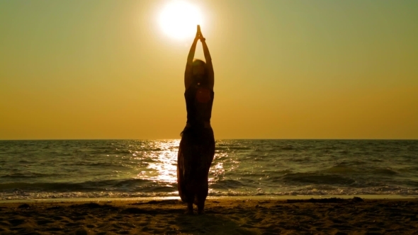 Girl Practicing Yoga On The Beach At Sunset Girl Practicing Yoga On The Beach At Sunset