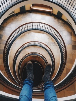 picture of legs dangling from tall spiral building