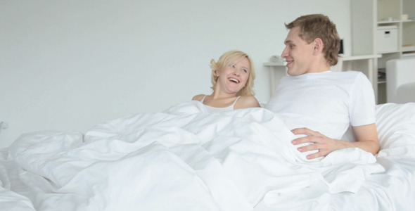 Couple lying in bed and chatting Couple lying in bed and chatting