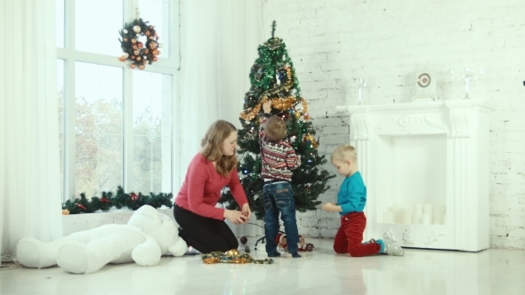 Mother And Children Decorate The Christmas Tree