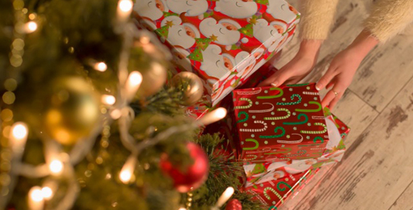 Girl Puts Presents Under the Christmas Tree