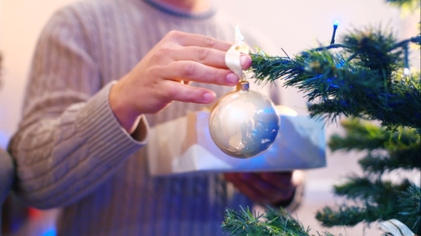 Male Hanging Balls On The Christmas Tree