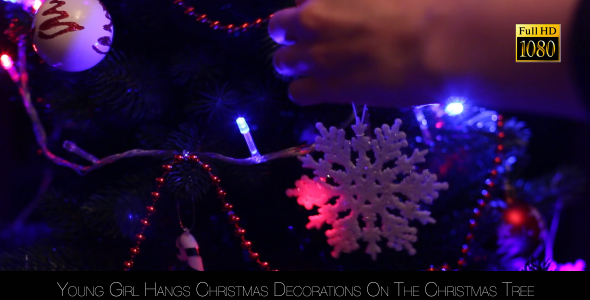 Young Girl Hangs Christmas Decorations On The Christmas Tree 4