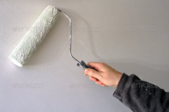 Painter Painting a House Wall with a Paint Roller