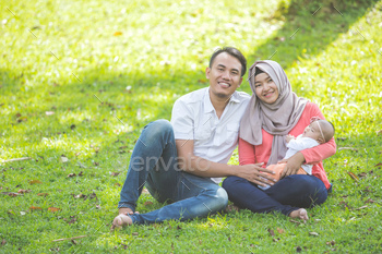 asian happy family with newborn baby in the park