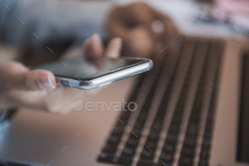 Photodune Artistic view of mobile technology at home: girl using a mobile phone and a laptop. 18478105