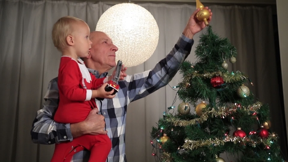 Grandfather With Boy Decorating Christmas Tree