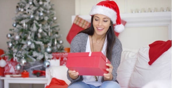 Excited Young Woman Opening a Christmas Gift