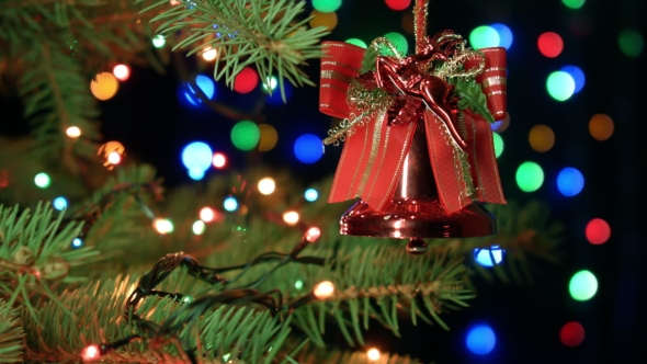 Christmas Bell On Christmas Tree With Blurred Lights Garlands, Fairy Background Holiday Atmosphere