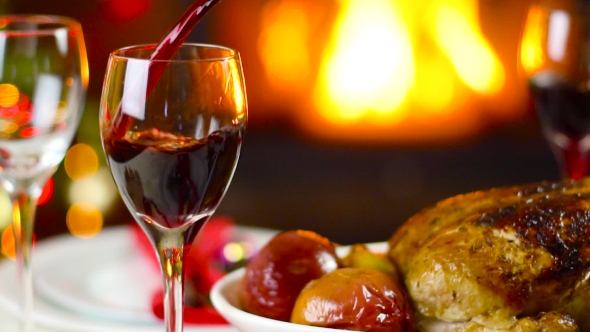 Wine Pouring To Glass On Christmas Table In Front Of Fireplace
