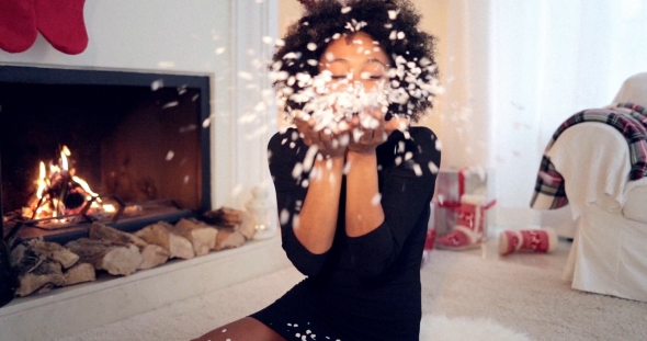 Young Woman Blowing Christmas Confetti