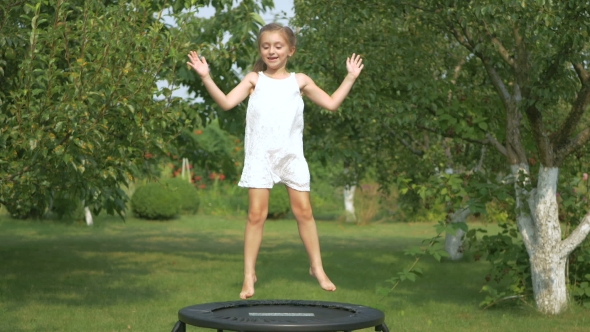 Videohive Little Girl Jumping on Trampoline in Garden 19077982