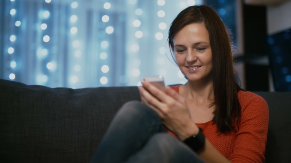 Attractive Woman Using Smartphone at Home on Christmas Eve Medium