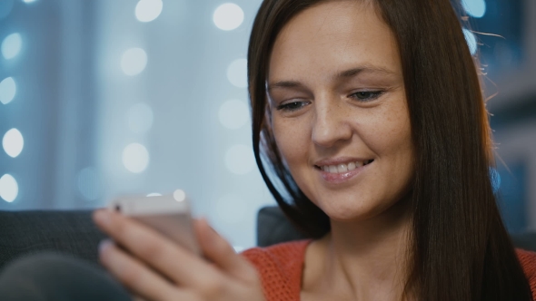 Attractive Woman Using Smartphone at Home on Christmas Eve