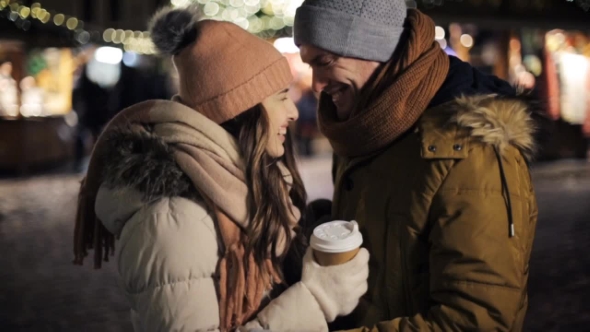 Happy Couple with Coffee Outdoors on Christmas