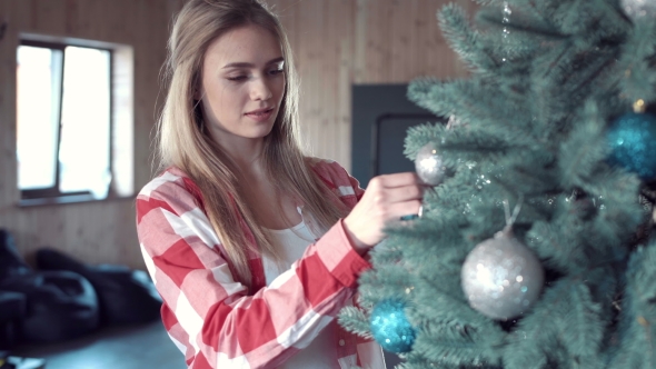 Woman Putting Balls at Christmas Tree