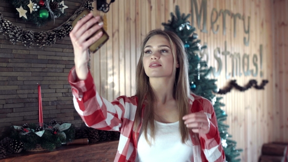 Woman Doing Selfie Against Christmas Decor