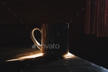 cup of coffee in a morning light, rustic wooden cottage interior 