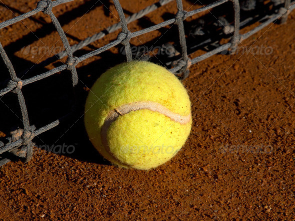 tennis ball on the ground near the net