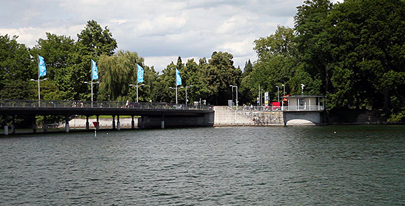 Bridge At Lake With Waving Flags Cars And People Bridge At Lake With Waving Flags Cars And People