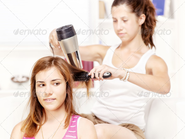 Teenage girl dries hair to her friends