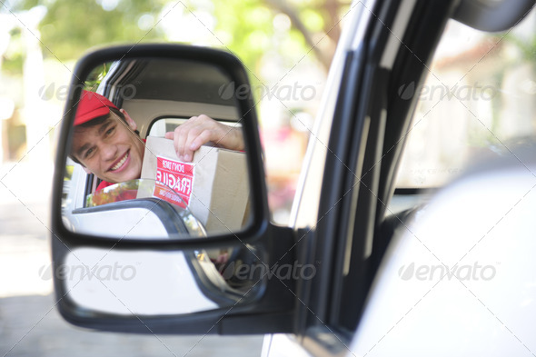 delivery courier in van, rear view mirror