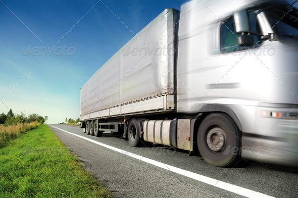 Silver truck driving on country road/motion blur