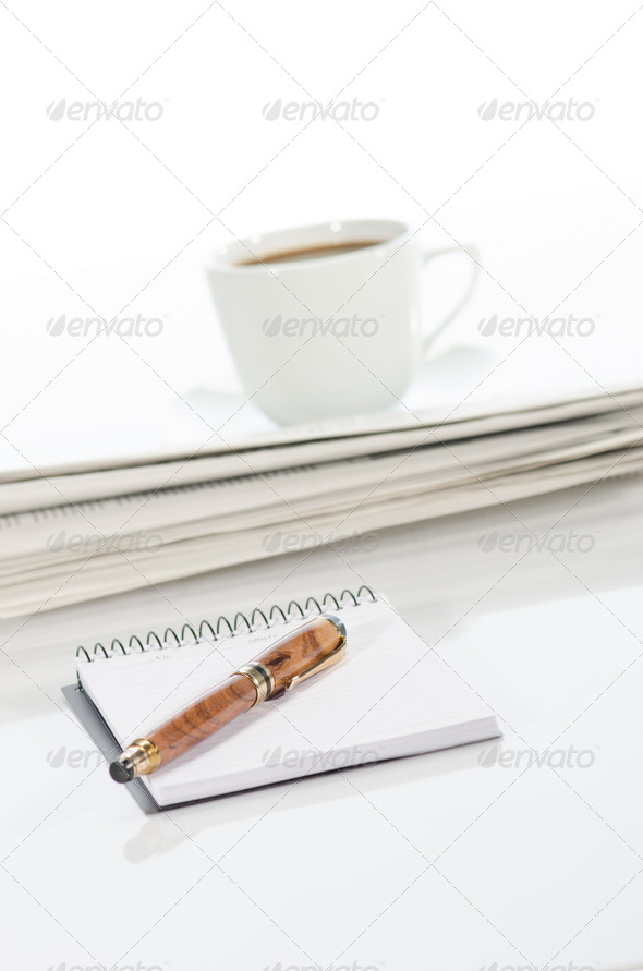 Notebook and pen, cup of coffee and newspaper