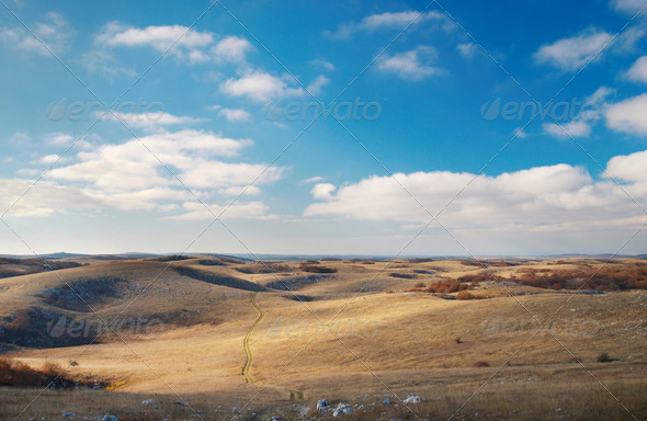 Panoramic landscape with hills and blue sky.