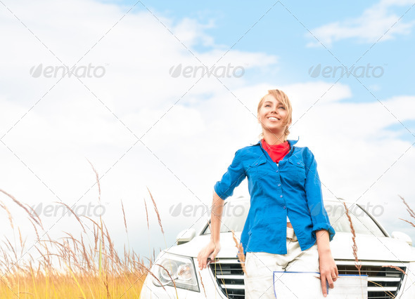 Tourist woman in front of car in summer field.