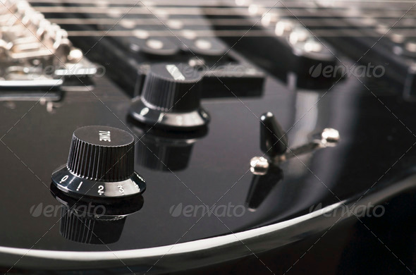 controls and cords, of a black electric guitar