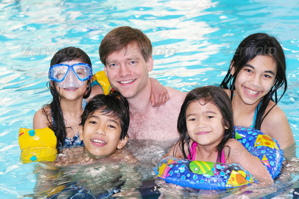 Father and four children in swimming pool