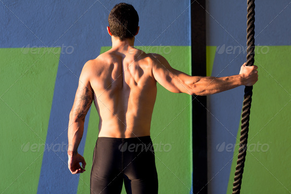Crossfit gym man holding hand a climbing rope - Stock Photo - Images