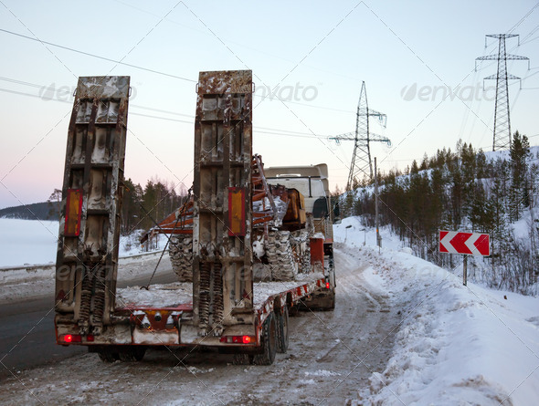 Tractor-trailer transports skidder