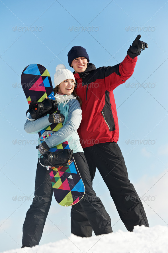 Happy sportswoman and sportsman with snowboard