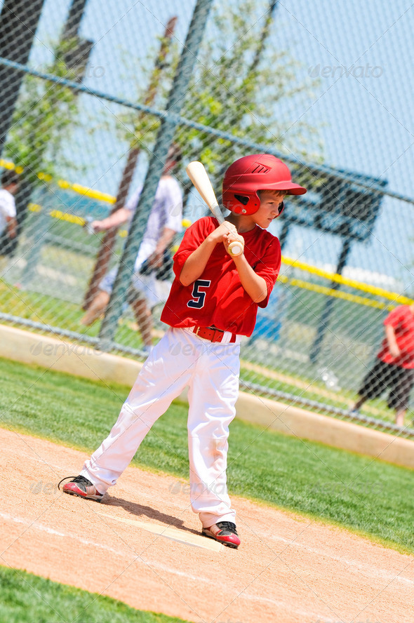 Youth baseball player with wood bat.
