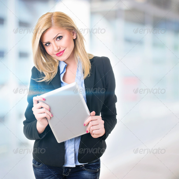 Attractive businesswoman in front of office holding digital tablet - Stock Photo - Images