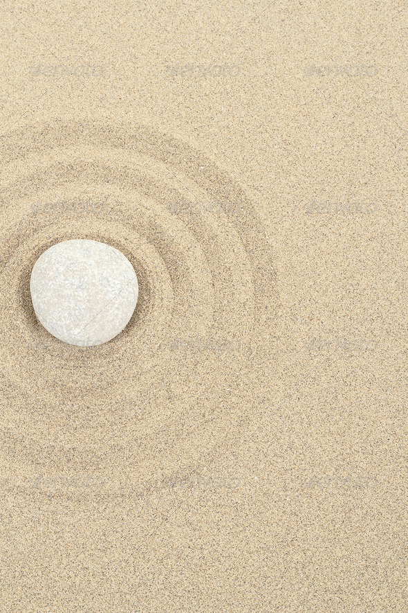 zen stone in sand with circles