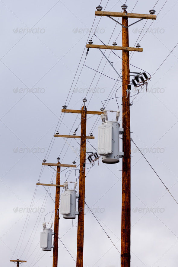 Row of utility poles power cables and transformers