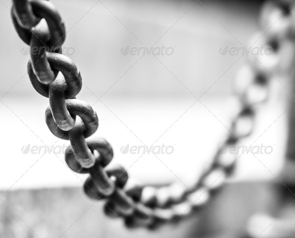 Focus on hanging metallic chain, part of fence.